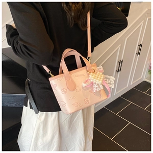 Detail of pink butterfly bucket bag with heart pearl charm and cute cartoon embossing