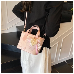 Detailed view of pink butterfly bucket bag with heart pearl charm and lace bow decor