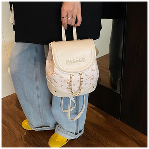 Detail of cream mini backpack with bear prints and decorative gold metal chain