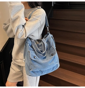 Detailansicht der blauen Denim-Umhängetasche mit Kordelzug und Vordertasche mit Schnalle