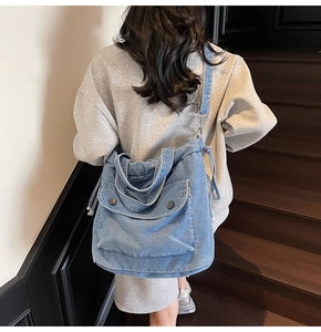 Detailansicht der Jeans-Einkaufstasche mit weißen Nähten und Kordelzug am Modell