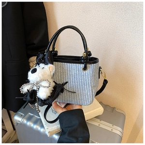 Détails du sac seau tissé bleu et blanc avec breloque chien en peluche blanc