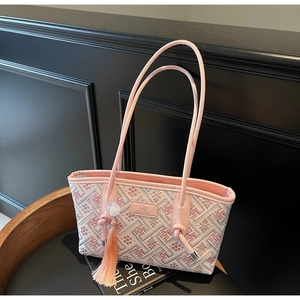 Detail der rosa bestickten Tragetasche mit geometrischen Mustern und Quasten-Accessoire