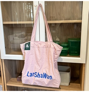 Détail du sac cabas en nylon rose avec imprimé LanShaWan bleu et écusson de chat