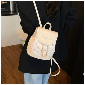 Mini cream backpack with cartoon mouse print and gold chain detail on model