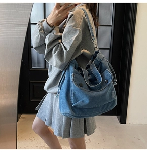 Detail der blauen Denim-Umhängetasche mit großem Fassungsvermögen und Kordelzugtaschen