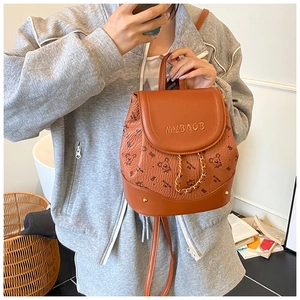 Detailed shot of a brown mini backpack featuring teddy bear patterns and a gold chain