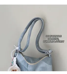 Gros plan du sac cabas texturé bleu clair avec fermeture éclair et breloque ours blanc