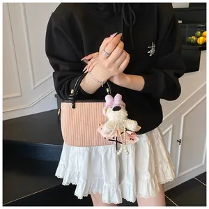 Sac seau tissé rose avec anses rondes noires et charmant pendentif en ours en peluche