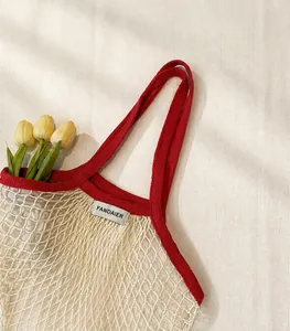 Detail of red and white woven cotton mesh tote bag with logo tag and tulips