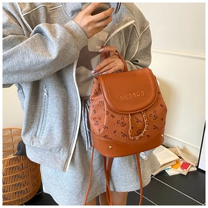 Close-up of brown faux leather backpack featuring cute bear print and gold chain detail