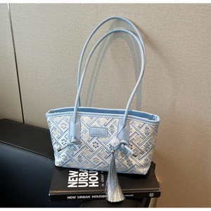 Detail der hellblauen Jacquard-Schultertasche mit Blumenstickerei und Silberquasten-Anhänger