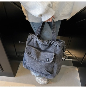 Detailansicht einer dunkelgrauen Vintage-Denim-Tragetasche mit Frontklappentasche