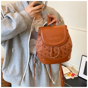 Detail of a brown PU leather mini backpack featuring cute bear prints and a gold chain strap