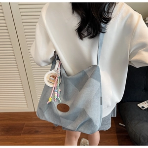 Détail du sac cabas en denim avec écusson Banatu et breloque Capybara mignonne