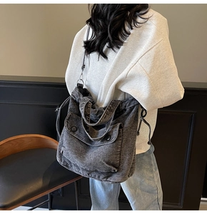 Detail der Crossbody-Tasche aus dunklem Denim mit Kordelzug und praktischen Taschen