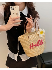 Sommerliche Strohtasche mit rosa Hello-Stickerei und Frangipani-Blume für den Strandurlaub