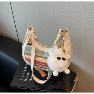 Detail of colorful woven straw bag with white leather trim and plush eyewear charm