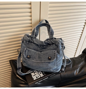 Detail der blauen Denim-Umhängetasche mit Faltenstruktur und Schultergurt