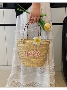 Strohhandtasche mit rosa Hello-Stickerei und Blumenakzent für den Sommerurlaub