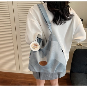 Détail du sac cabas en denim avec logo Banatu en cuir marron et breloque Capybara mignonne