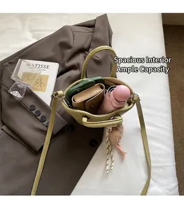 Capacité interne du sac seau en cuir vert clair avec téléphone, portefeuille et parapluie