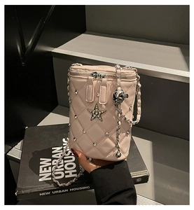 Détail du sac seau matelassé rose clair avec rivet étoile et boule de chaîne argent