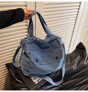 Nahaufnahme der Denim-Umhängetasche mit Kordelzug und vorderer Klappentasche im Detail