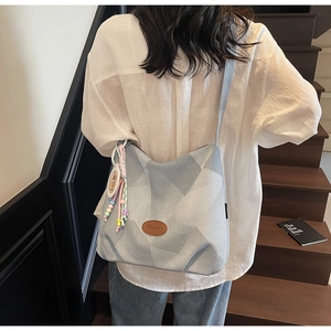 Détail du sac cabas gris avec logo Banatu en cuir et pompons de perles colorées
