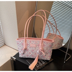 Detailansicht der rosa Stickerei-Schultertasche mit geometrischen Mustern und Quasten