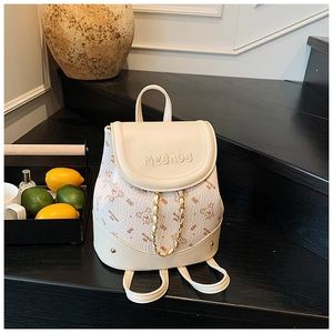 Close-up of a white mini backpack featuring bear prints and MYBAOB embossed logo detail