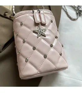 Vue détaillée du sac bandoulière rose matelassé orné de strass et d'une étoile métallique