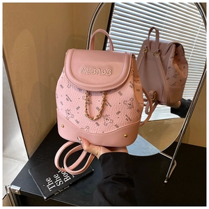 Detail of pink leather mini backpack with cartoon bear patterns and gold metal chain