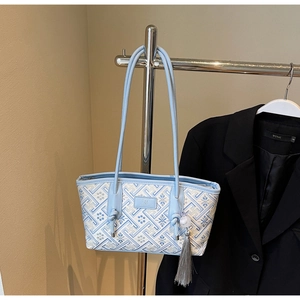 Detail der Stickerei an hellblauer Shopper-Tasche mit Quaste und Lederriemen