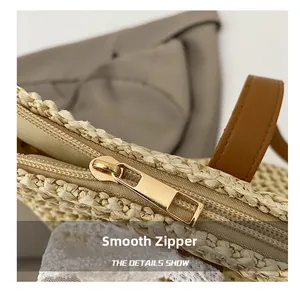 Close-up of smooth gold metal zipper and premium woven texture on the straw tote bag