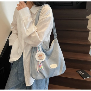 Détail du grand sac cabas en jean bleu clair avec écusson Banatu et bijou de sac