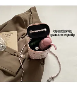 Vue détaillée du sac seau matelassé rose montrant sa capacité pour téléphone et parapluie