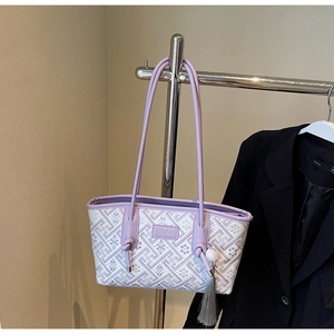 Detailansicht der lila Stickerei mit schicker Quaste und Perlenanhänger an der Tasche