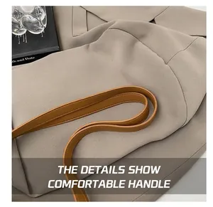 Detail of comfortable brown leather handles on a large woven tote bag with clean stitching