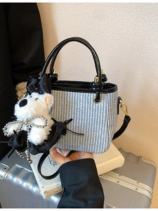 Sac seau tissé bleu avec poignées en cuir noir et breloque chiot en peluche blanche