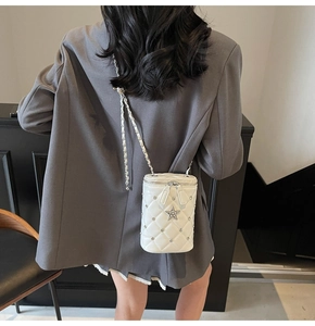 Détail du sac seau blanc matelassé avec étoile en strass et bandoulière chaîne