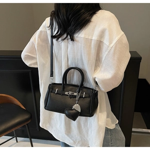 Vista posteriore della borsa in pelle nera con ciondolo a cuore e chiusura argento