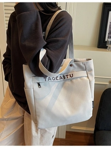 Minimalist beige canvas tote bag with front zipper pocket and large capacity for daily use