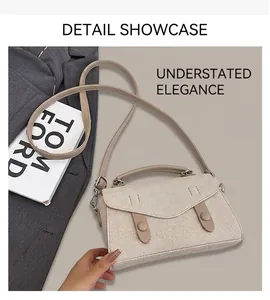 Detail of beige textured flap handbag with top handle and adjustable shoulder strap