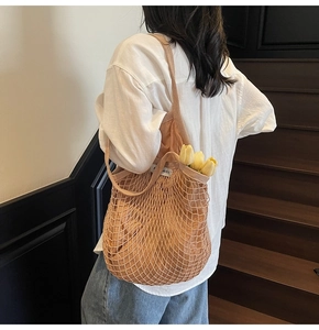 Detail van beige geweven mesh tas met zichtbare binnenvoering en schouderriem ontwerp