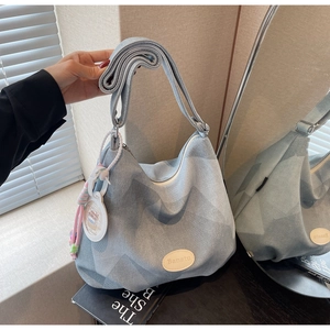 Détail du sac hobo bleu clair à texture géométrique avec perles et bandoulière large
