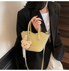 Détail du sac seau vert citron avec breloque ours et foulard sur mannequin