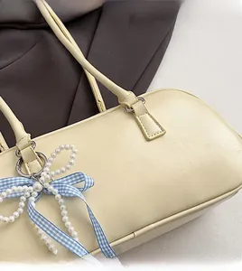 Dettaglio borsa a cuscino color crema in ecopelle con nastro a quadri e perle