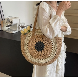 Detail view of woven sunflower straw bag with leather straps and summer boho style