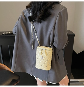 Détail du sac seau matelassé beige avec breloques étoiles argentées et strass